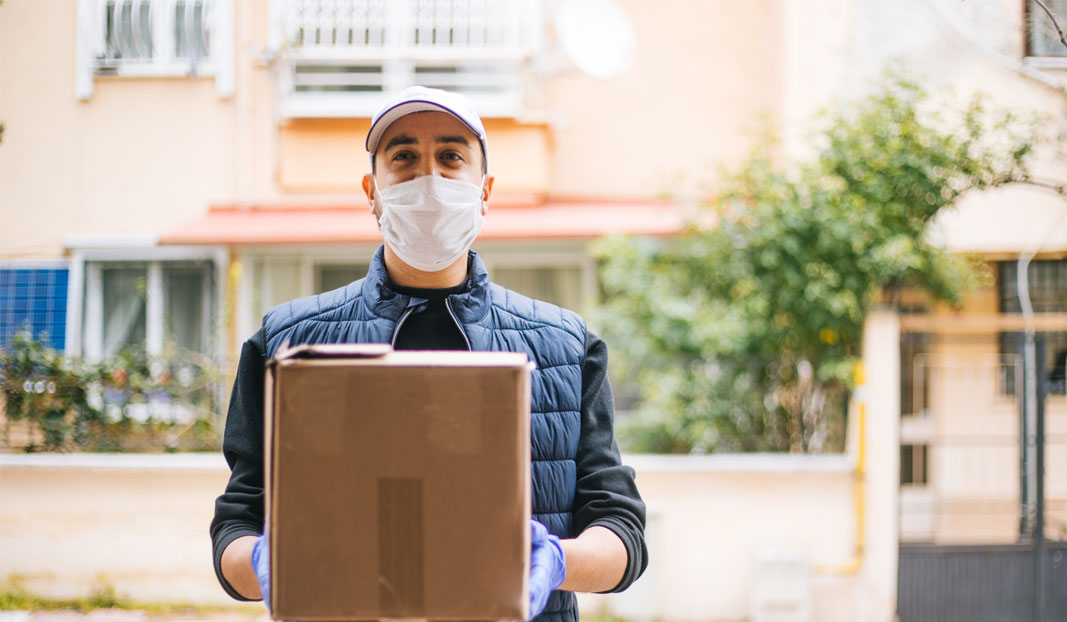 Key worker delivering a package, wearing a mask for protection