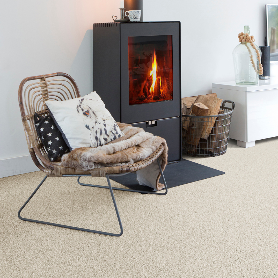 Severus saxony carpet in colour 03 Washed linen in a lounge with a fireplace and chair