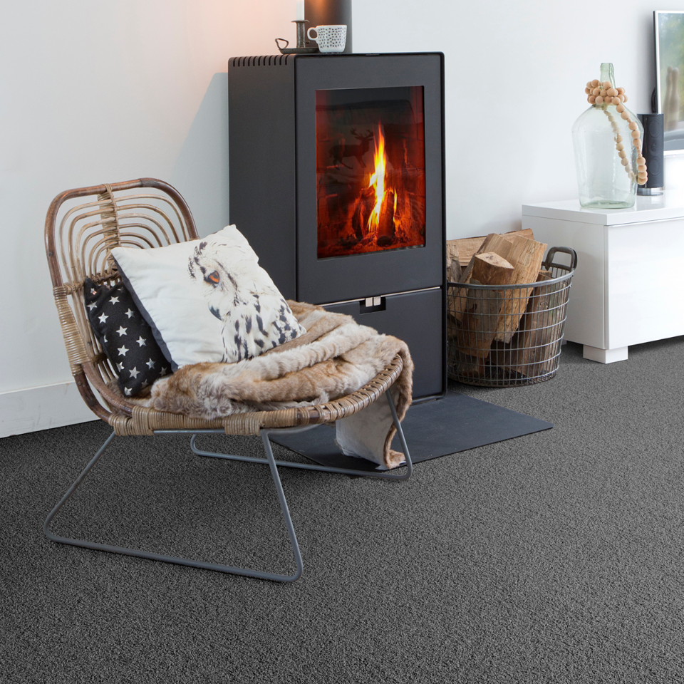 Severus saxony carpet in colour 97 Autumn moore in a lounge with a fireplace and chair