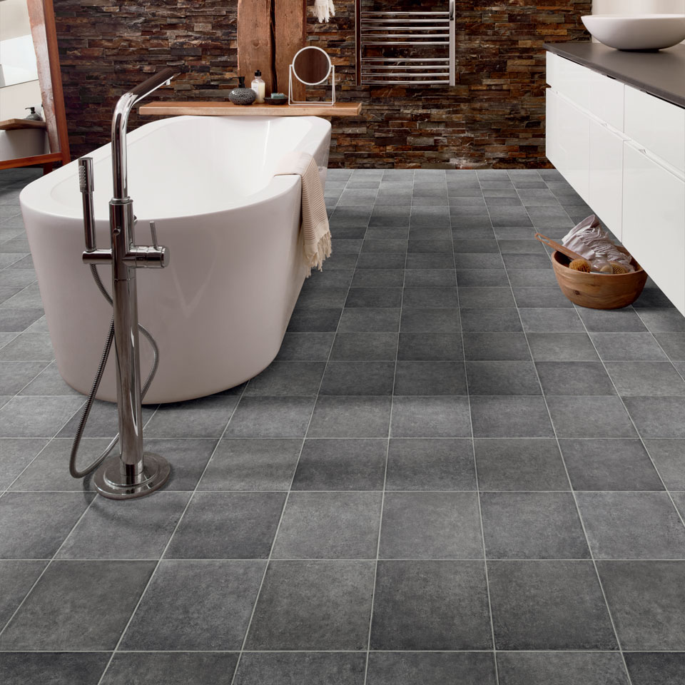 Dark grey tile effect vinyl flooring in bathroom with freestanding bath