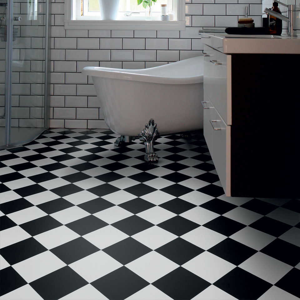 Black and white tile ffect vinyl in bathroom with rolltop bath