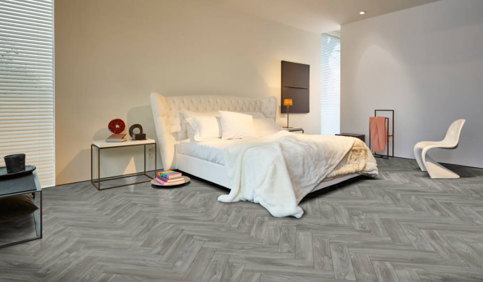 Wood effect vinyl in a spacious bedroom with a comfy bed